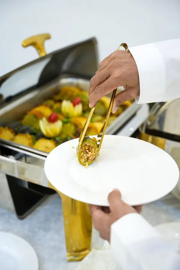 كراسي ذهبية فاخرة مع طاولات بيضاء في الباقة الذهبية